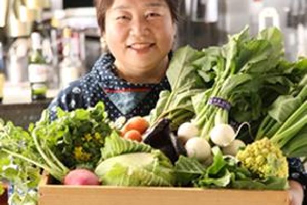 Japanische Bäuerin mit einem Gemüsekorb in der Hand